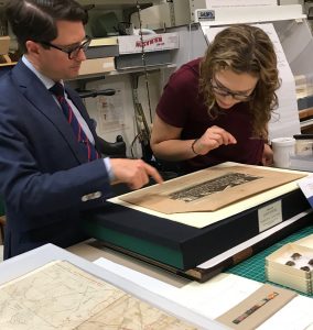male professor and female student examine a photograph from the First World War