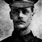 black and white newspaper photograph close up of First World War soldier with a moustache and hat with cap badge of the Queen's Royal West Surrey Regiment